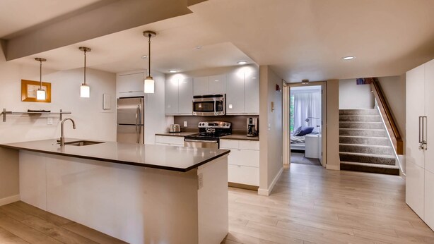 A modern kitchen with a central island, built-in appliances, and pendant lighting. - Sts. Johns 2507 (Keystone)