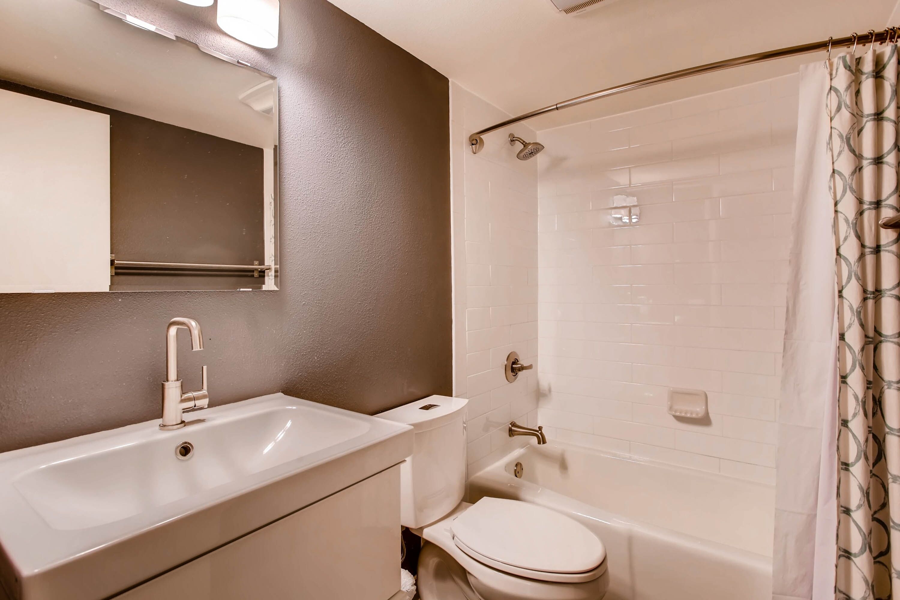 A bathroom with a sink, toilet, and shower.