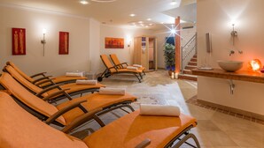 Un cuarto de spa con sillones reclinables, una camilla de masaje, un lavabo y una escalera.