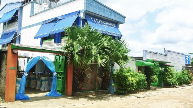 A hotel with a blue awning and a sign that reads "HOTEL DE LA RENARDIERE." - Hôtel La Renardière (Douala)