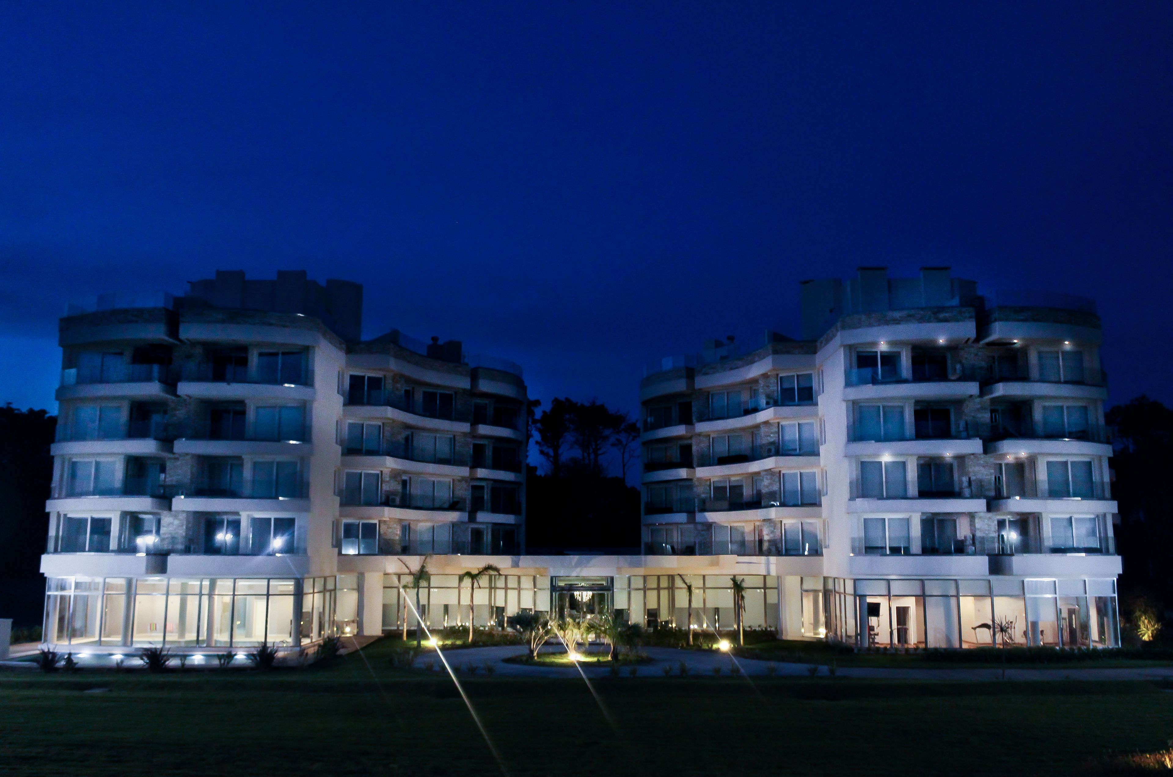 Un hotel de varios pisos con un patio central, ventanas amplias y un diseño arquitectónico moderno.
