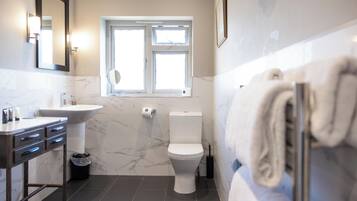 Un baño con lavamanos, inodoro y ventana.
