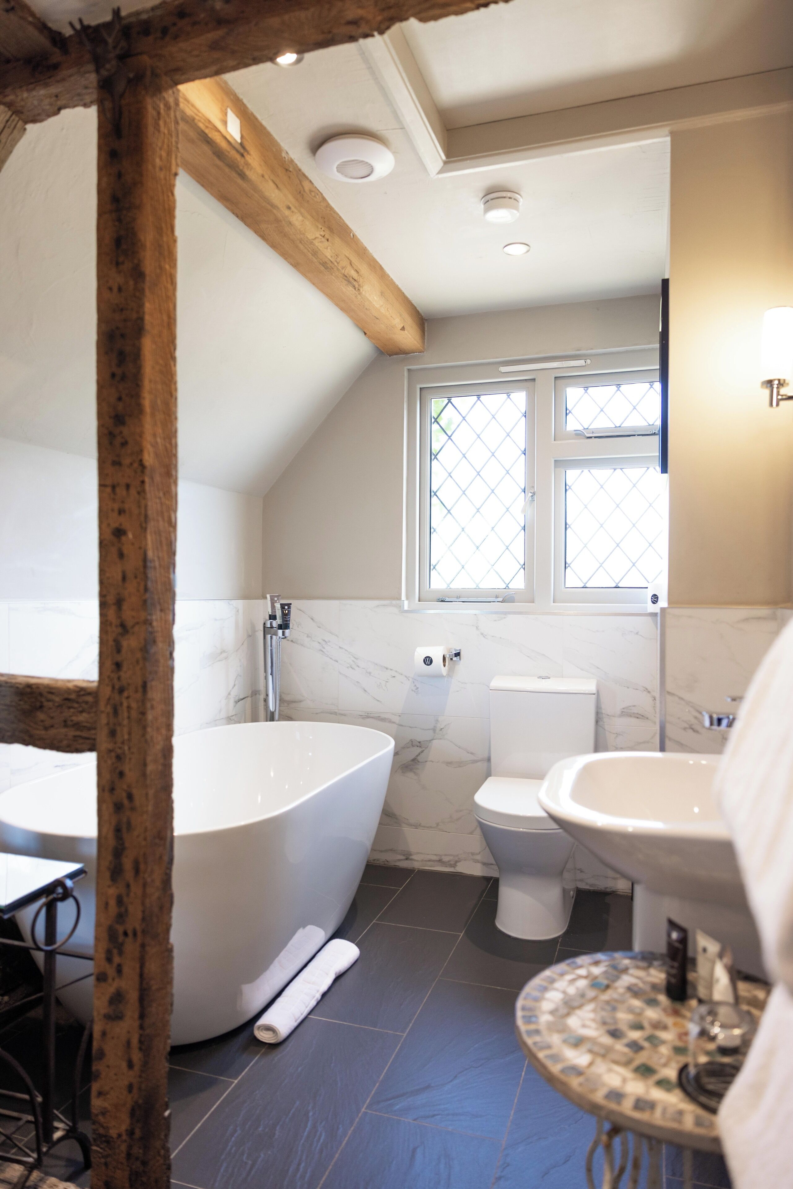 Une salle de bain avec une baignoire sur pieds, des toilettes et un lavabo.