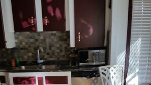 A compact kitchen with a microwave, toaster, and a Samsung printer on a glass table. - Just You in Neepawa Vacation Home (Neepawa)