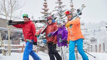 A group of people skiing with skis and poles in a snowy outdoor setting.
