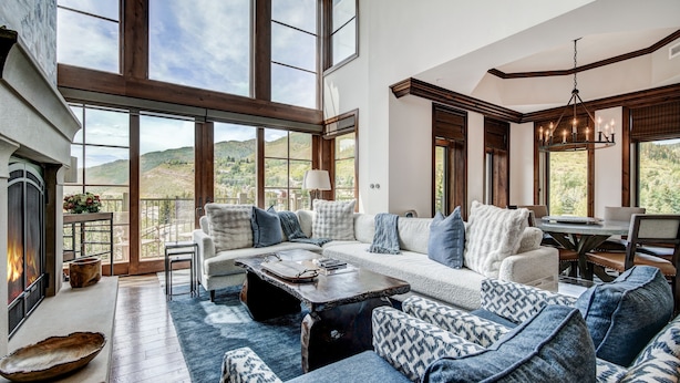 Un salón espacioso con ventanas amplias, una chimenea y vistas al exterior.