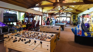 Ein Indoor-Erholungsbereich mit Tischfußball, Spielautomaten und Billardtisch.