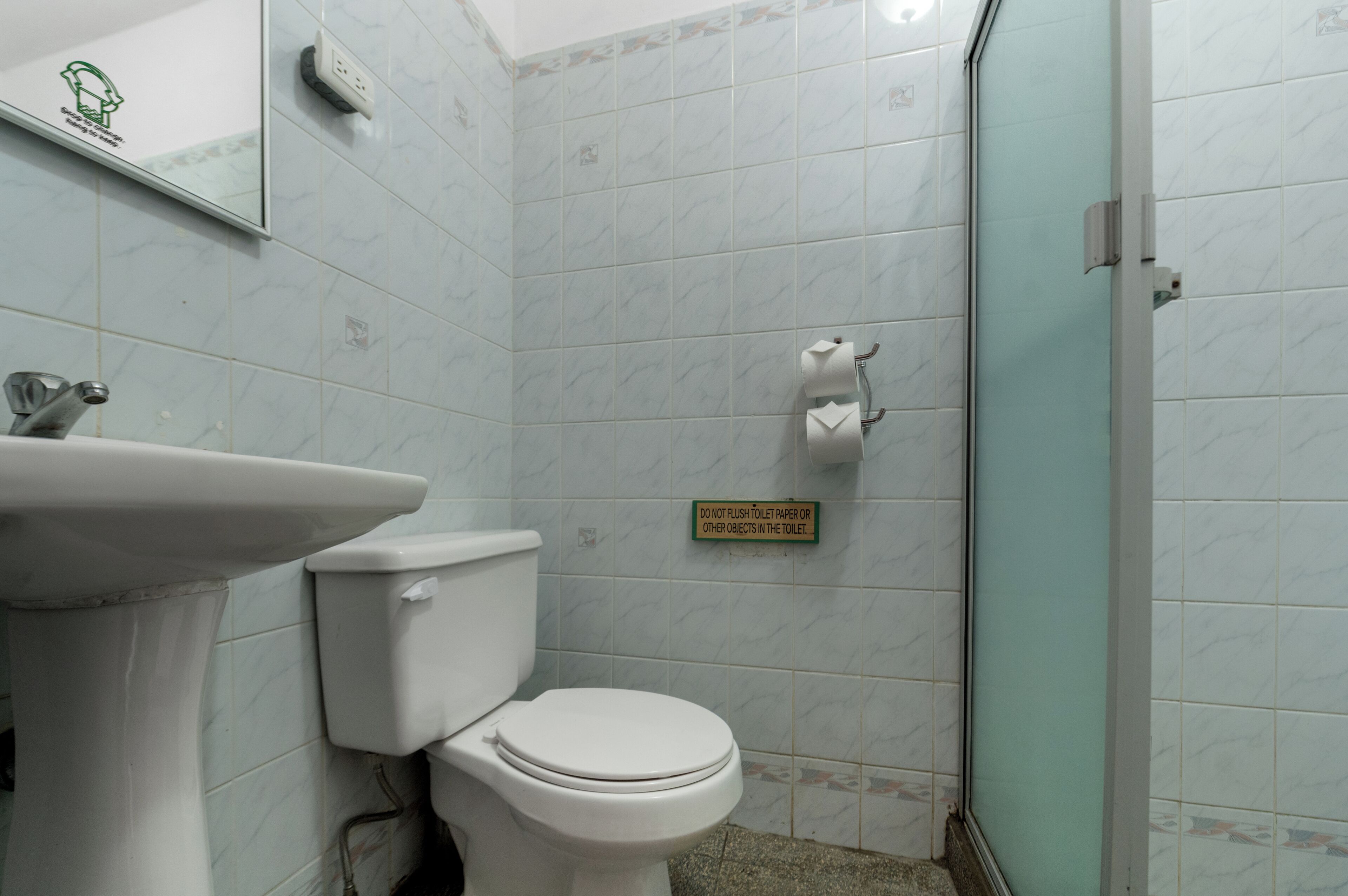 Une salle de bain comprenant des toilettes, un lavabo et un espace douche.
