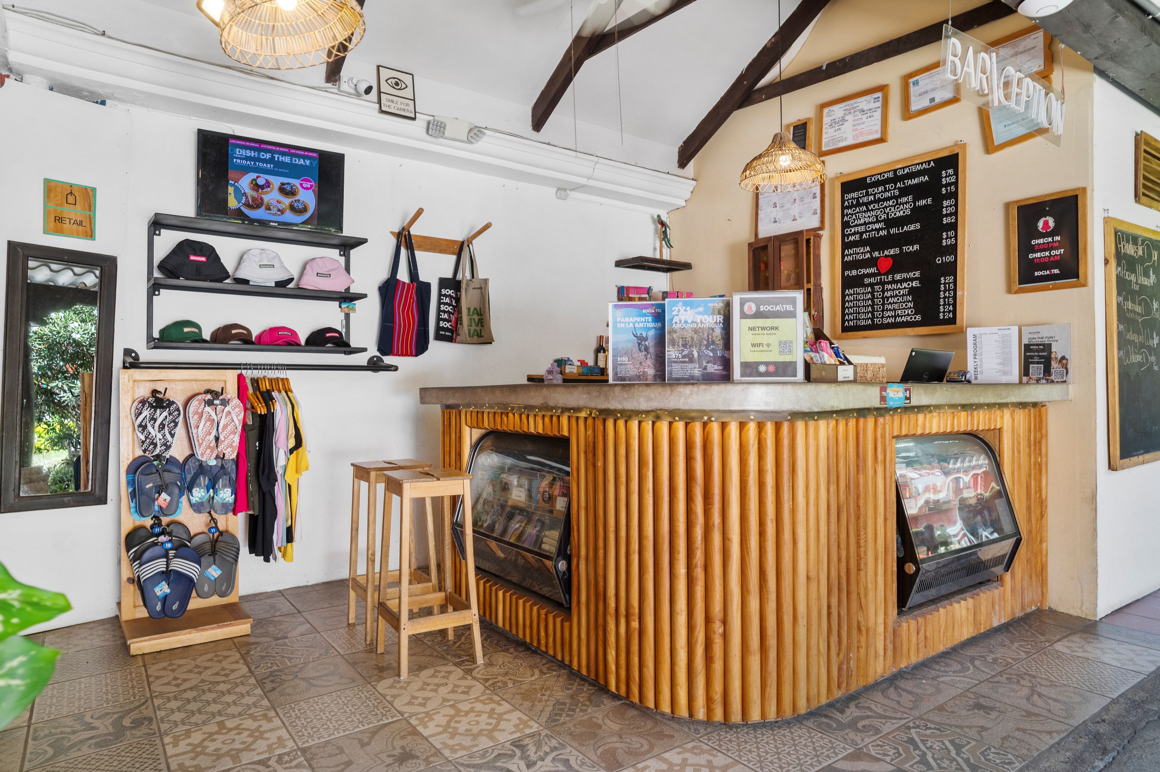 Zona de bar con mostrador, taburetes y diversos objetos exhibidos en estantes y sobre el mostrador.