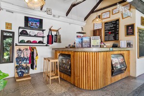 A bar area with a counter, stools, and various items displayed on shelves and the counter. - Socialtel Antigua (Antigua Guatemala)