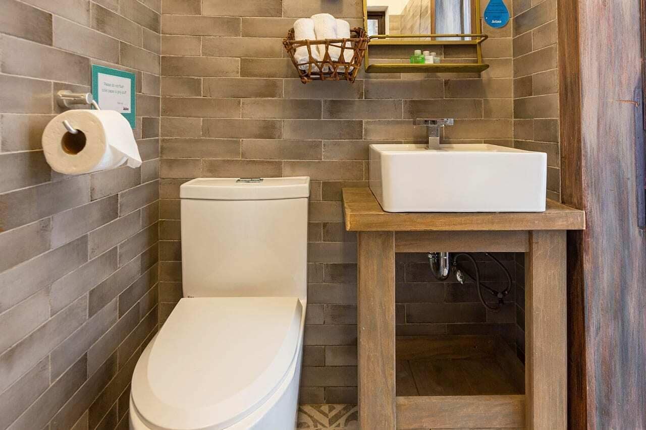 Ein modernes Badezimmer mit Toilette, Waschbecken und einem Korb mit Handtüchern.