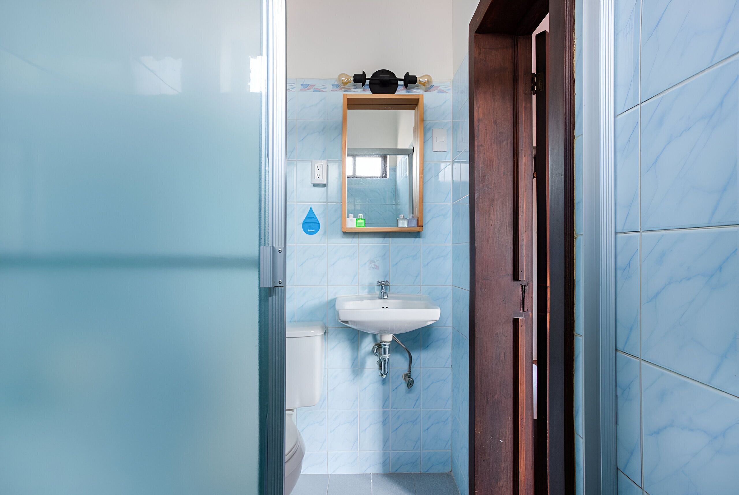 Un baño con lavabo, espejo y retrete.
