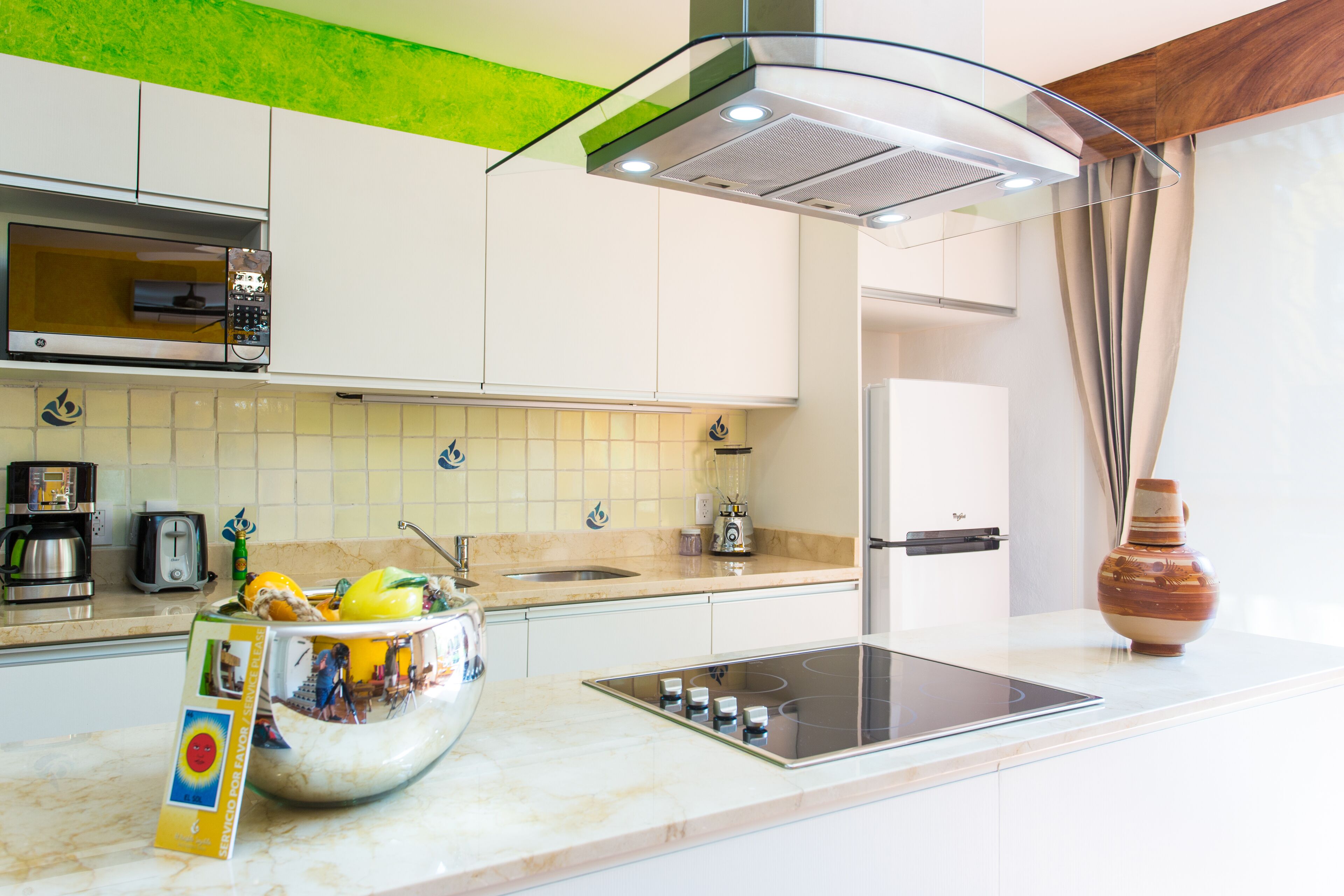 Una cocina moderna con horno empotrado, estufa a gas y un bol grande de fruta en la encimera.