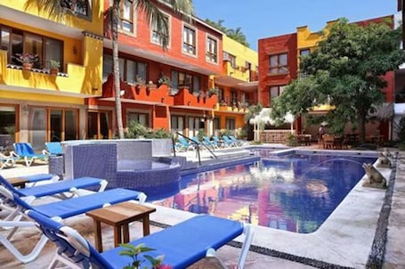 Una piscina al aire libre, sombrillas, sillones reclinables de piscina. Casa Lotería -Pueblito Sayulita- Colorful, Family and Relax Experience with Private Parking and Pool