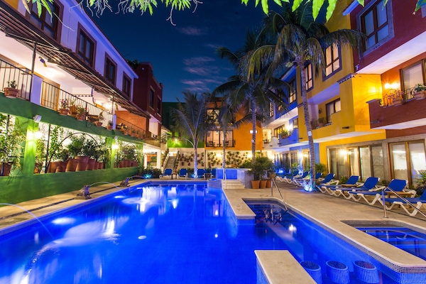 Alberca al aire libre, sombrillas en la alberca y camastros