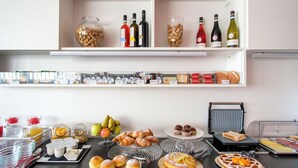 Montaje de bufé con diferentes opciones de comida, bebidas y una máquina para hacer gofres.