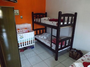 A bunk bed room with a crib and a bag on the floor. - Hotel Anjo Gabriel (Penha)
