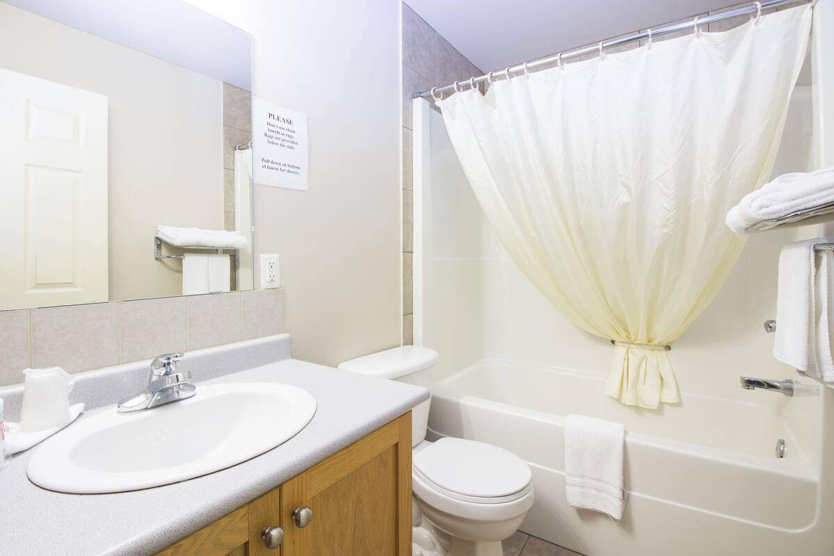 A bathroom with a sink, toilet, and bathtub.