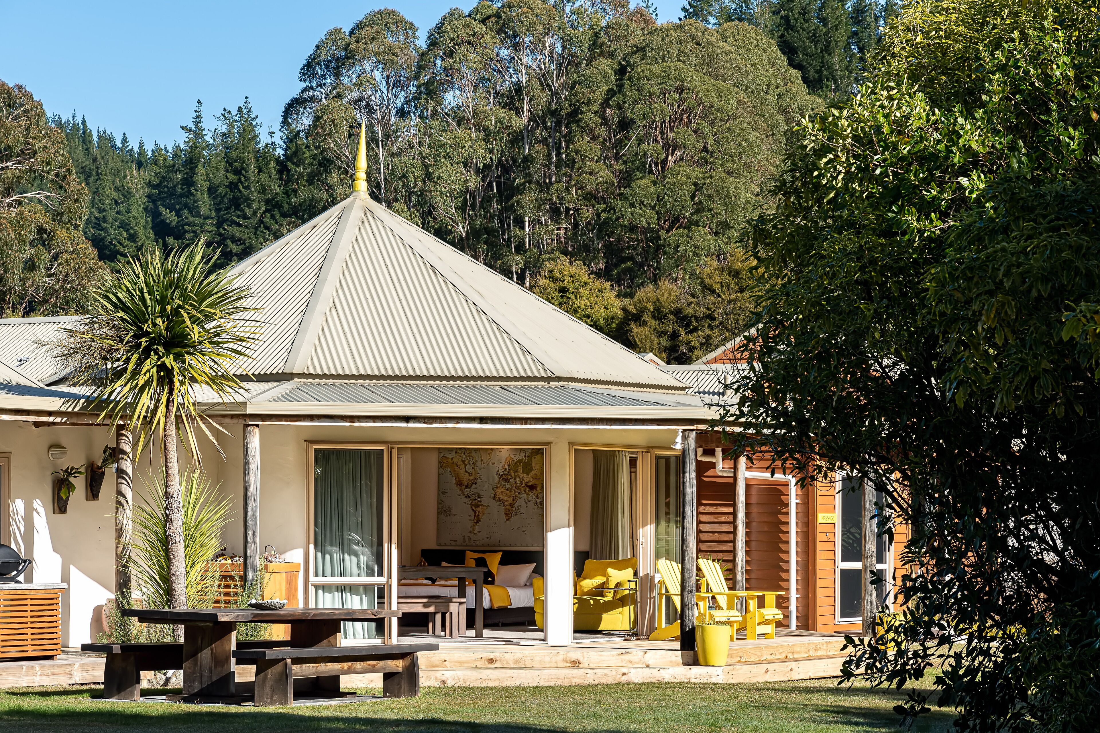 A cozy lodge with a large bed, dining area, and a patio with outdoor seating.