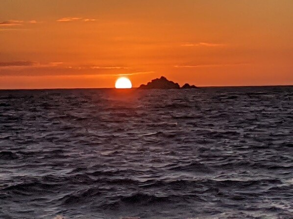A sunset over the ocean with a rocky outcrop in the distance. - Kailua Oceanfront-60' Lap Pool - Upscale Quiet Neighborhood - Legal (Kailua)