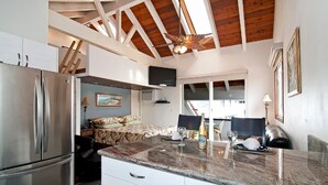 Una cocina moderna con encimera de mármol, electrodomésticos de acero inoxidable y ventilador de techo.