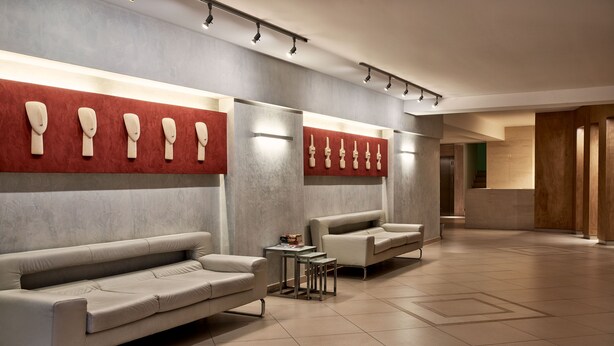 A modern lobby with a sofa, chairs, and a small table. - Favie Suzanne by GHH (Tinos)
