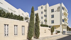 A modern hotel with a flat facade, multiple balconies, and a clear blue sky. - Favie Suzanne by GHH (Tinos)