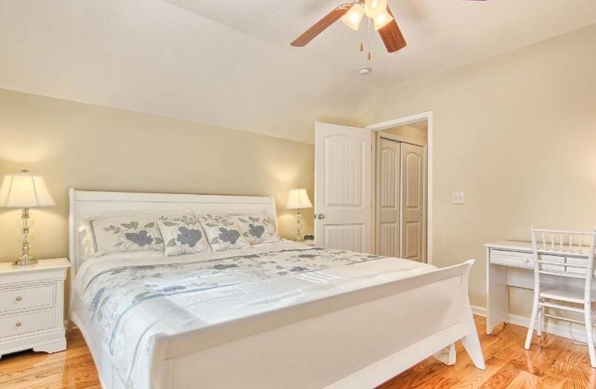 Une chambre à coucher comprenant un lit, des tables de chevet, un bureau et une armoire.