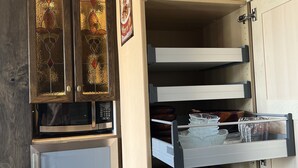 A kitchen with wooden cabinets, a refrigerator, and a microwave.