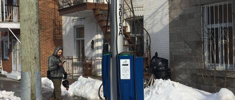 Un poste de electricidad con una acera nevada y un cartel de no estacionamiento.