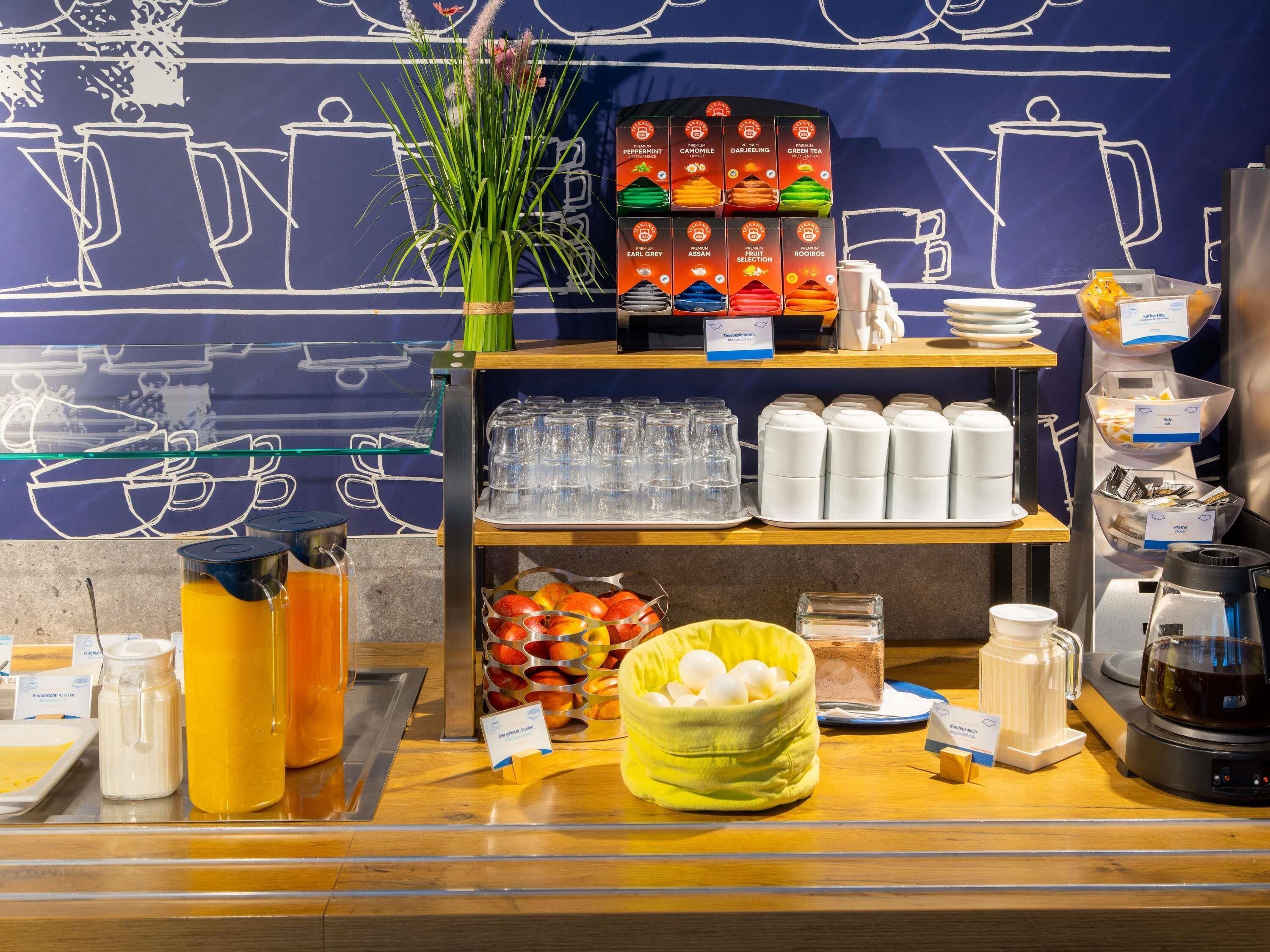 A coffee station with various beverages and a selection of tea boxes.