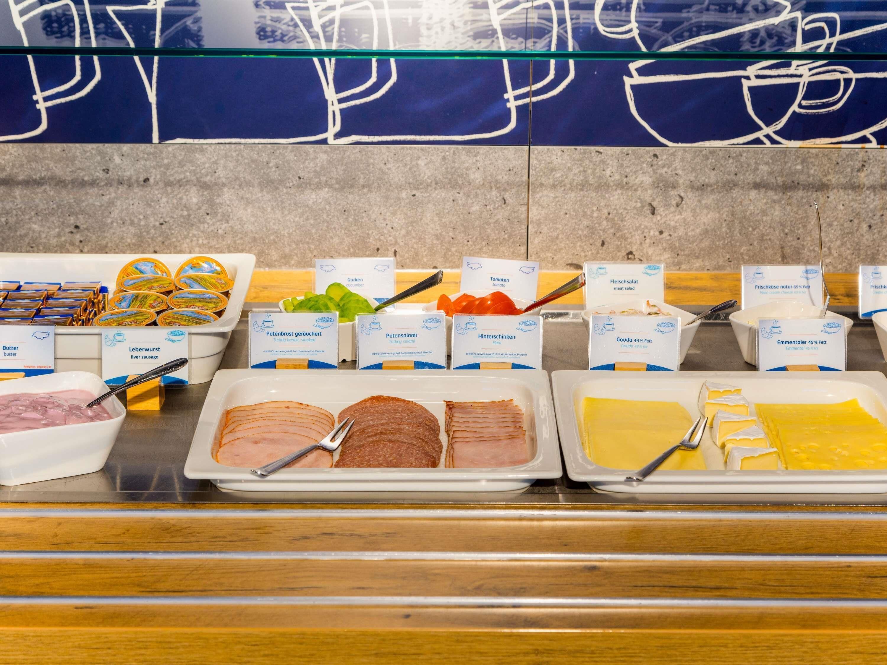 Un buffet proposant une variété de plats, notamment de la saucisse de foie, du blanc de dinde et du fromage.