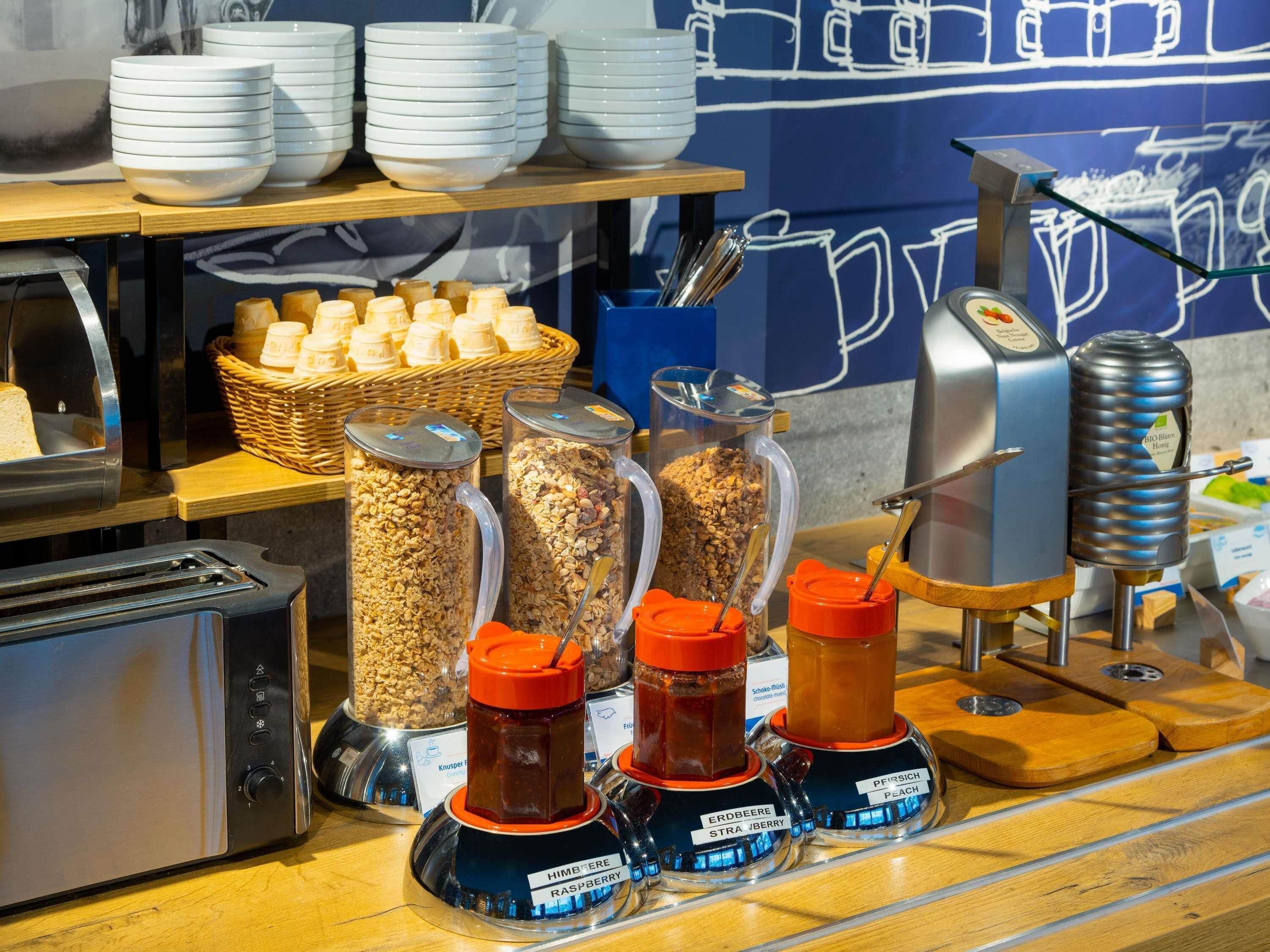 A buffet area with various food items, including cereal, granola, and condiments.