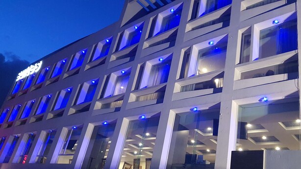 Un immeuble à plusieurs étages doté d’une architecture moderne, caractérisé par une série de balcons et de grandes fenêtres.