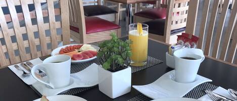 Un desayuno con tostadas, huevos y una bebida de frutas.