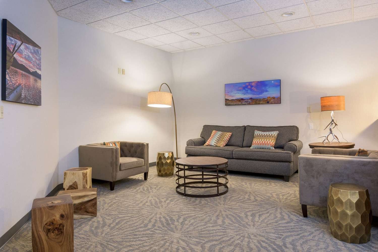 A modern living room with a grey sofa, a round coffee table, and a floor lamp.