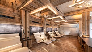 Une salle de spa avec un plancher en bois, des fauteuils suspendus et un comptoir d’accueil.