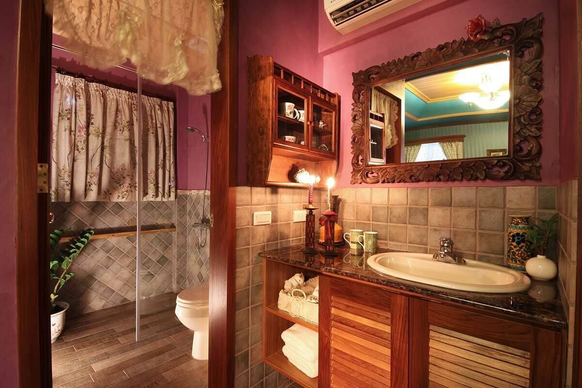 A bathroom with a wooden vanity, a mirror, and a shower area with a curtain.