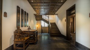 A traditional interior with a staircase, wooden furniture, and wall-mounted decorations. - Lijiang Zhuyun boutique Hotel (Lijiang)