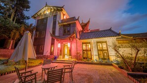 A traditional building with a tiled roof and a courtyard with seating. - Lijiang Zhuyun boutique Hotel (Lijiang)