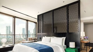 Une chambre d’hôtel moderne avec un grand lit, une vue sur la ville et un panneau décoratif mural.