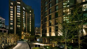 A modern hotel with a curved facade, multiple floors, and illuminated windows.