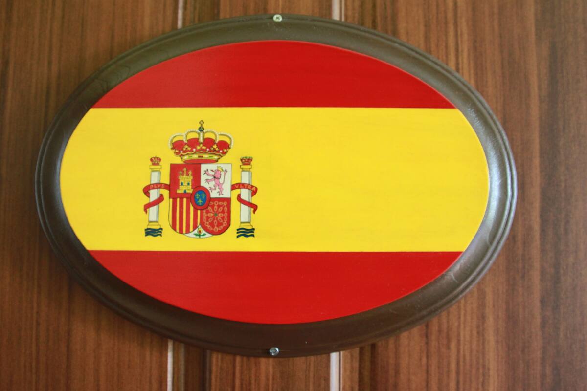 Un emblema colgado en la pared con una bandera roja y amarilla que presenta un escudo de armas.