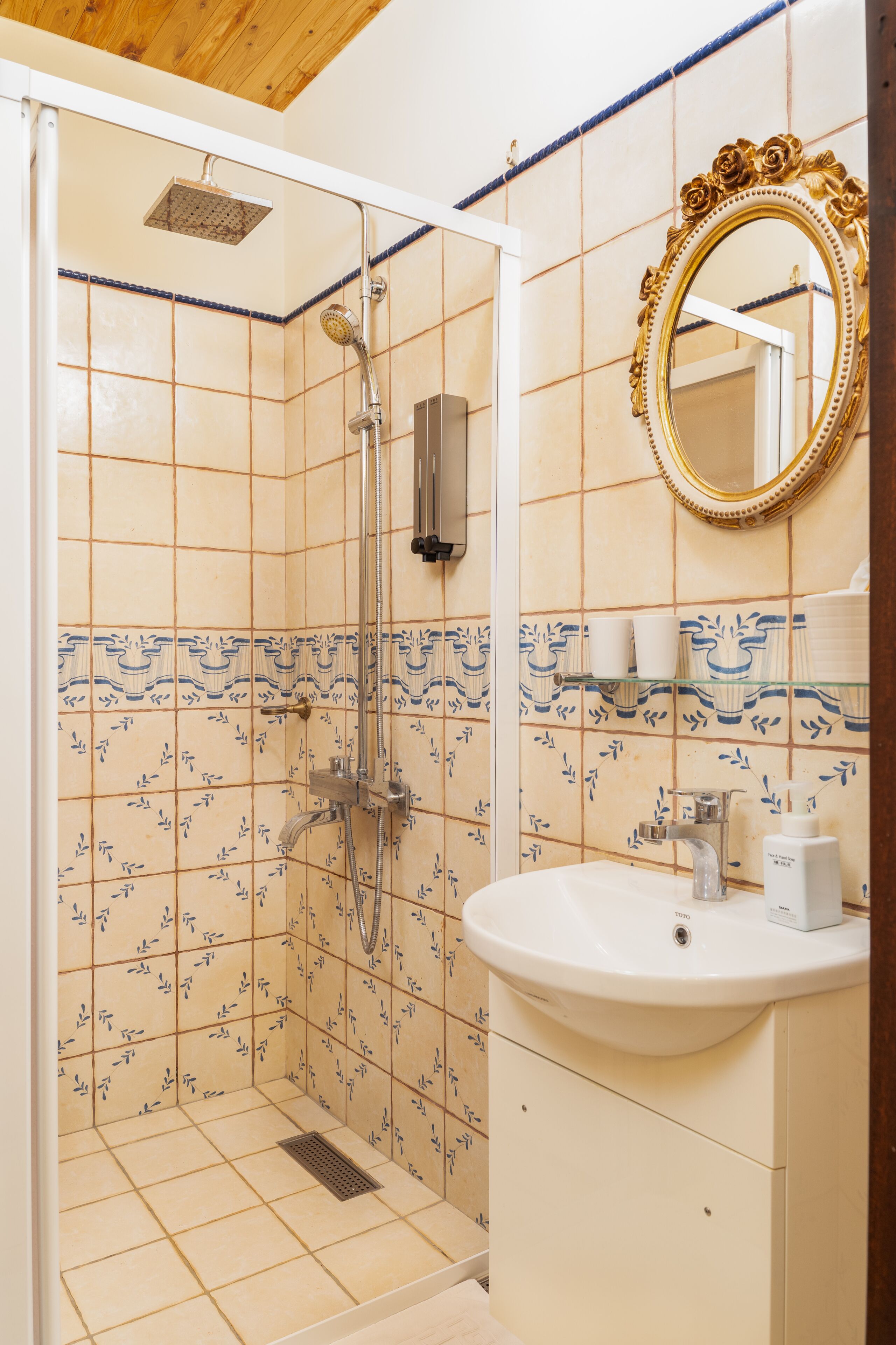 Une salle de bain avec une douche, un lavabo et un miroir.