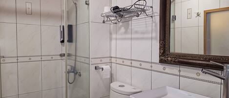 Une salle de bain avec douche, toilettes et lavabo.