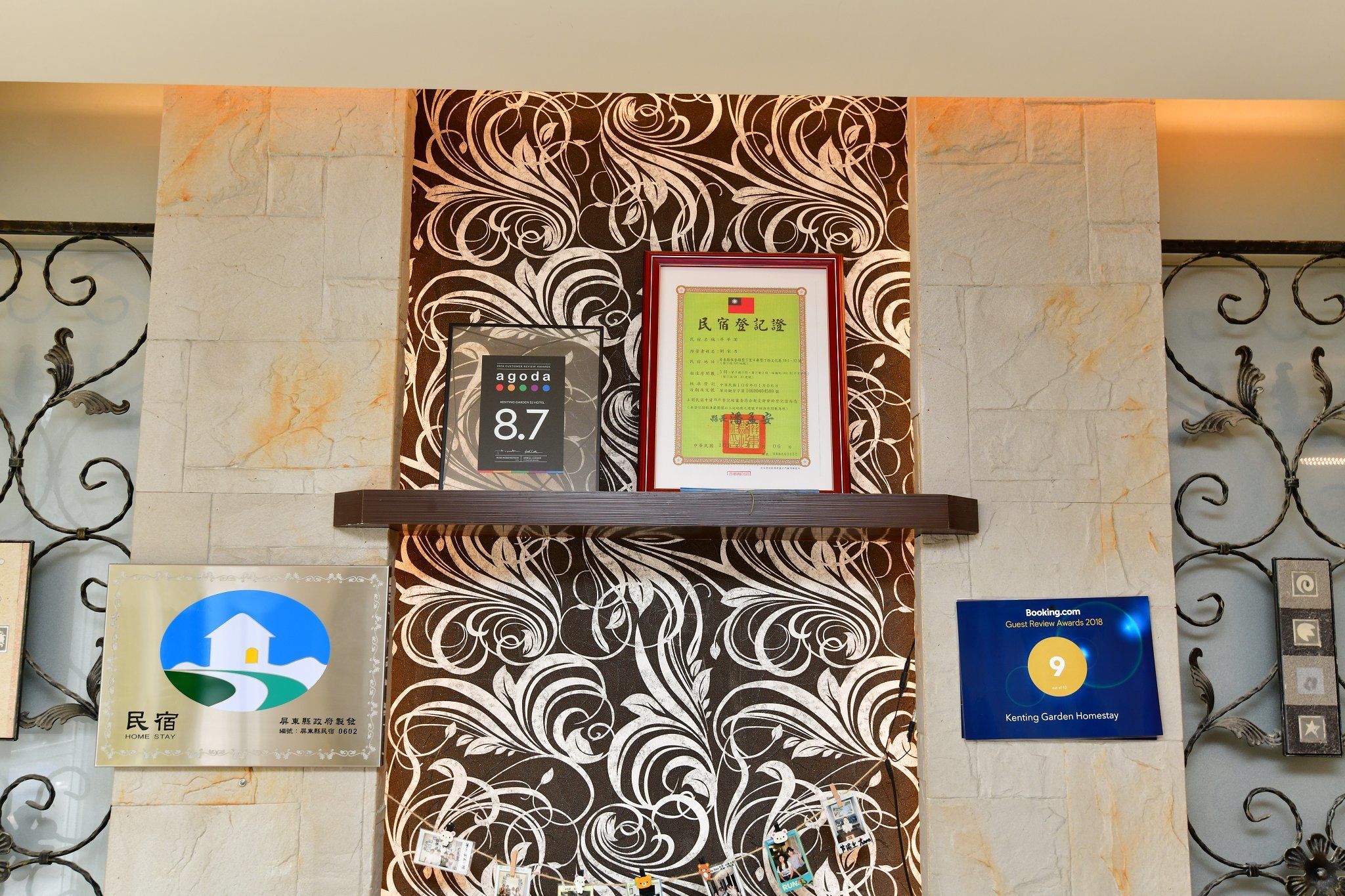 A reception area with a marble wall, framed certificates, and a rating sign.