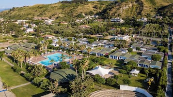 Un quartiere residenziale con diverse case, una piscina e un piccolo anfiteatro.