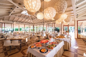 A spacious dining area with multiple tables, a buffet setup, and large hanging paper lanterns. - Le Dune Beach Club (Messina)