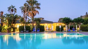 A swimming pool with lounge chairs and palm trees. - Le Dune Beach Club (Messina)