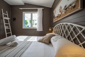 A bedroom with a bed, a ladder, a window with curtains, and a wall-mounted picture. - Le Dune Beach Club (Messina)